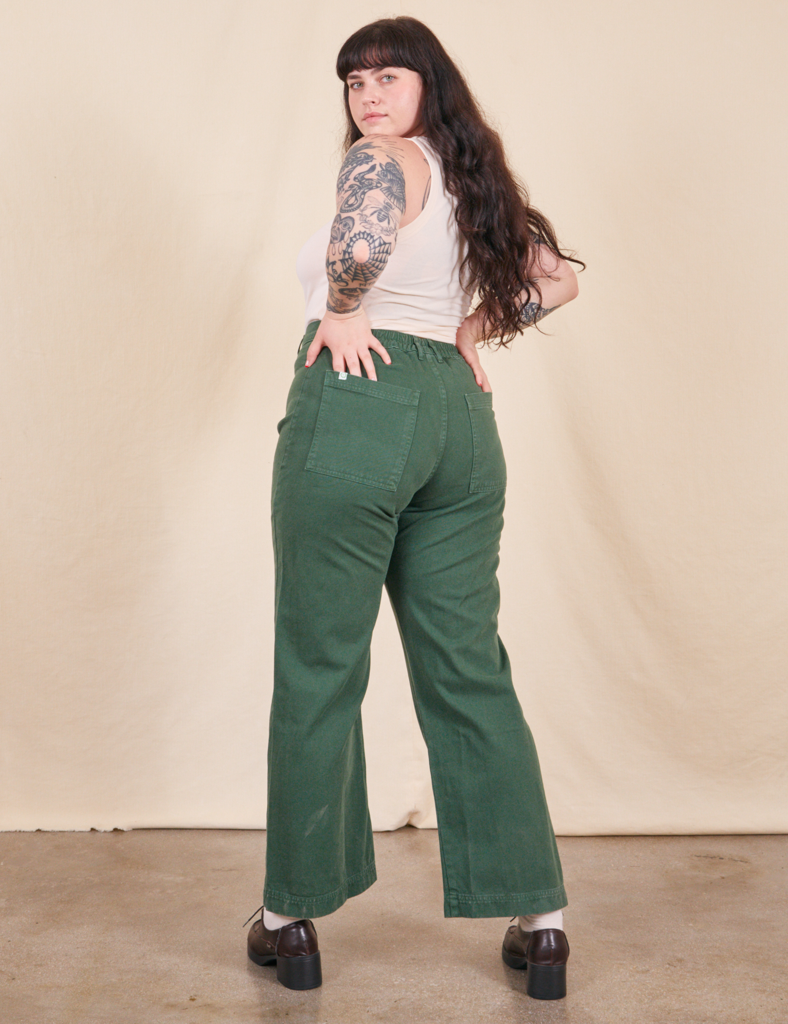 Back view of Western Pants in Dark Emerald Green and vintage off-white Tank Top on Sydney